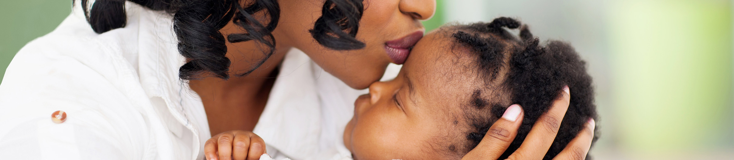 Mother kissing baby on forehead